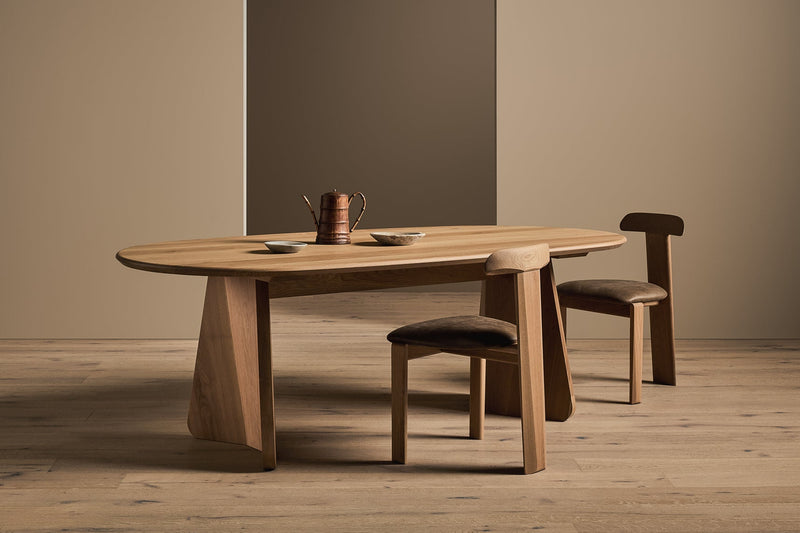 Wooden dining table with two chairs in a minimalistic room.